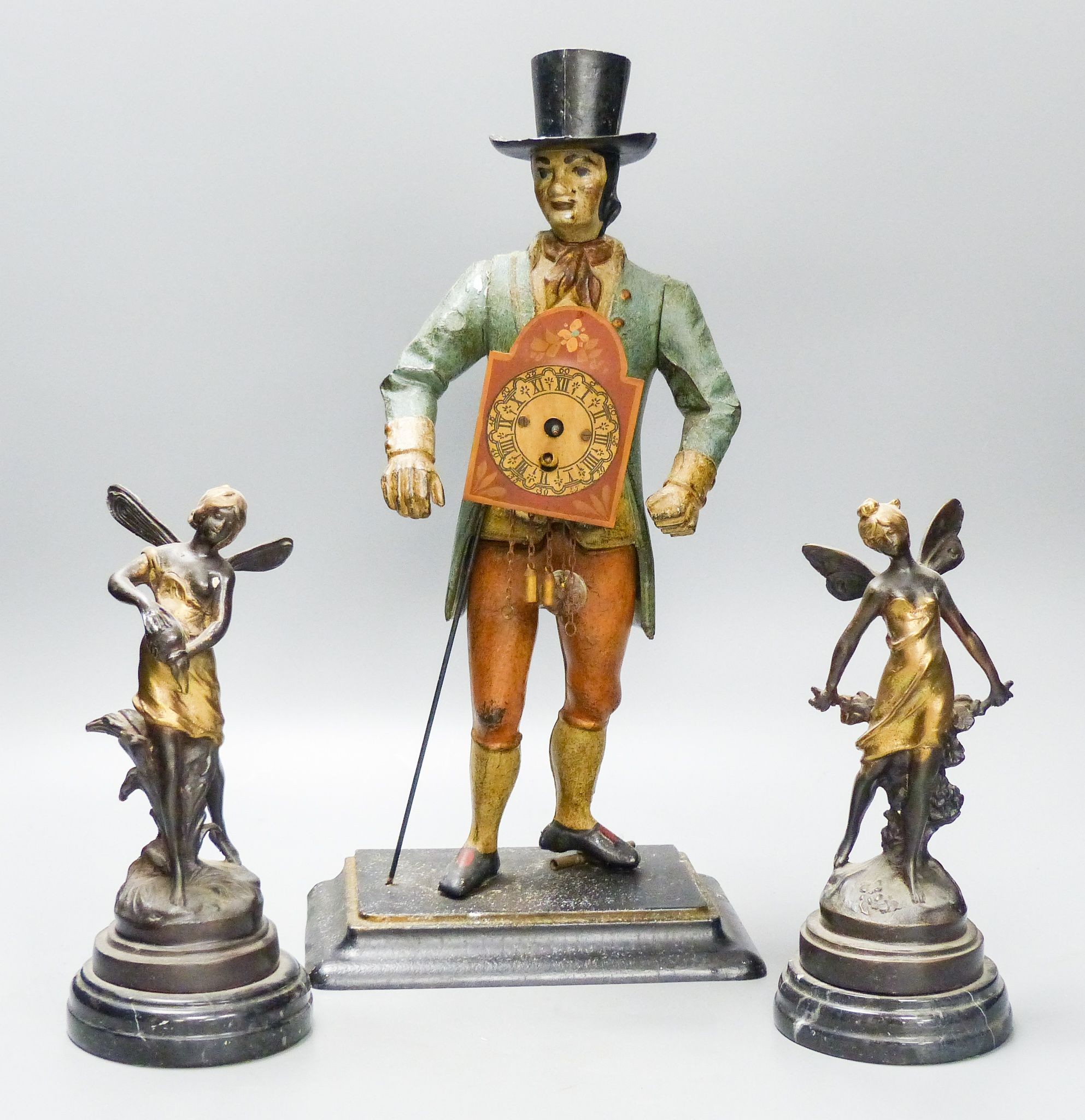 A painted cast iron figure all mantle timepiece and a pair of bronze figures of fairies, tallest 40 cm high